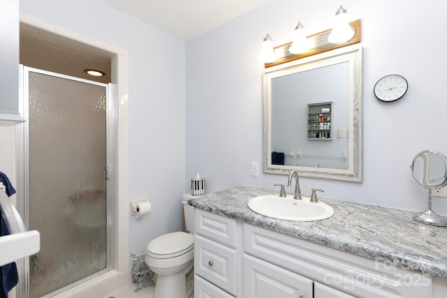 bathroom with a stall shower, vanity, and toilet