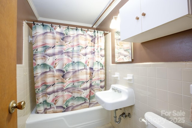 full bathroom with shower / tub combo, tile walls, toilet, ornamental molding, and a sink