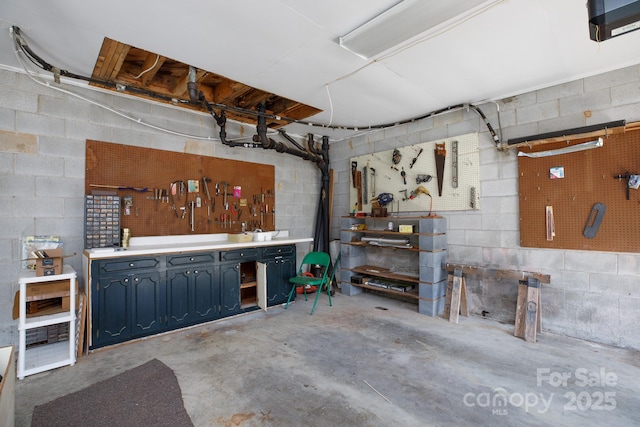 basement with concrete block wall and a workshop area