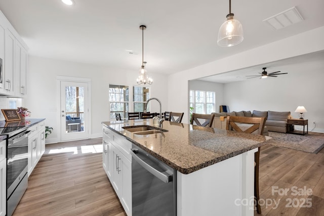 kitchen with visible vents, appliances with stainless steel finishes, light wood-style floors, white cabinets, and a sink