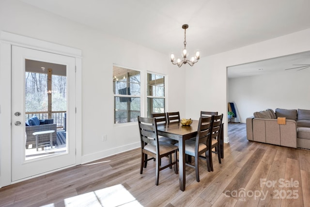 dining space featuring a notable chandelier, baseboards, and wood finished floors