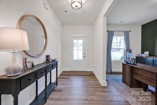 entrance foyer with wood finished floors, visible vents, and baseboards