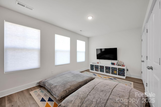 bedroom featuring visible vents, baseboards, and wood finished floors