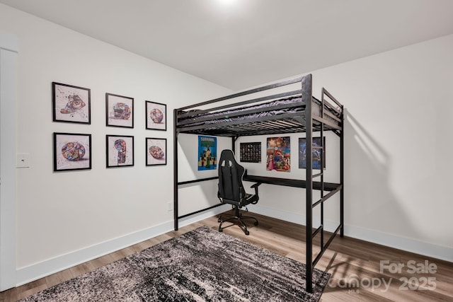 bedroom featuring baseboards and wood finished floors