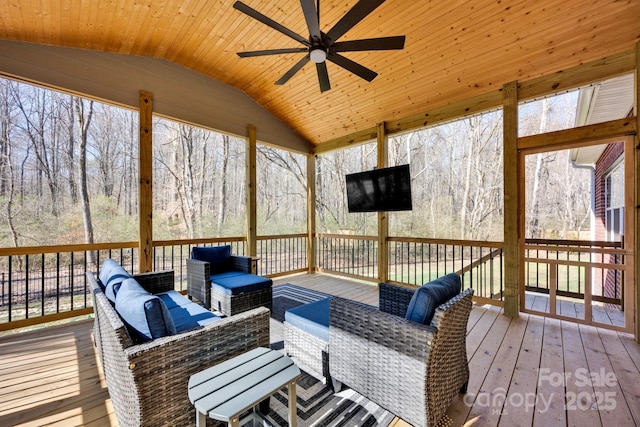 sunroom featuring lofted ceiling, wooden ceiling, and a ceiling fan