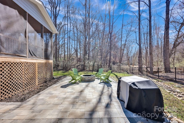 view of patio / terrace with a sunroom, an outdoor fire pit, a fenced backyard, and area for grilling