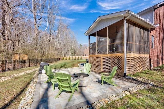 view of patio featuring an outdoor fire pit, a fenced backyard, a sunroom, and a ceiling fan