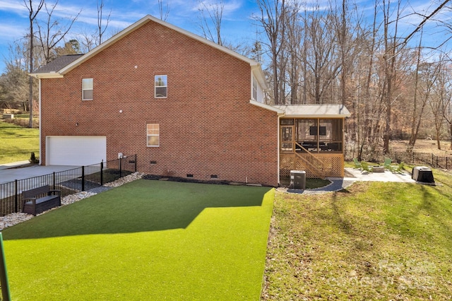 view of home's exterior featuring driveway, a sunroom, crawl space, fence, and brick siding