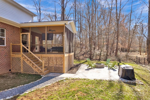 view of yard with a patio, an outdoor fire pit, fence, a sunroom, and stairs