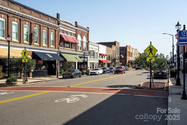 view of street with street lights, curbs, traffic signs, and sidewalks