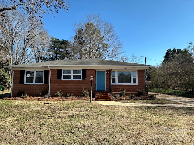 ranch-style house with entry steps, a front lawn, and brick siding