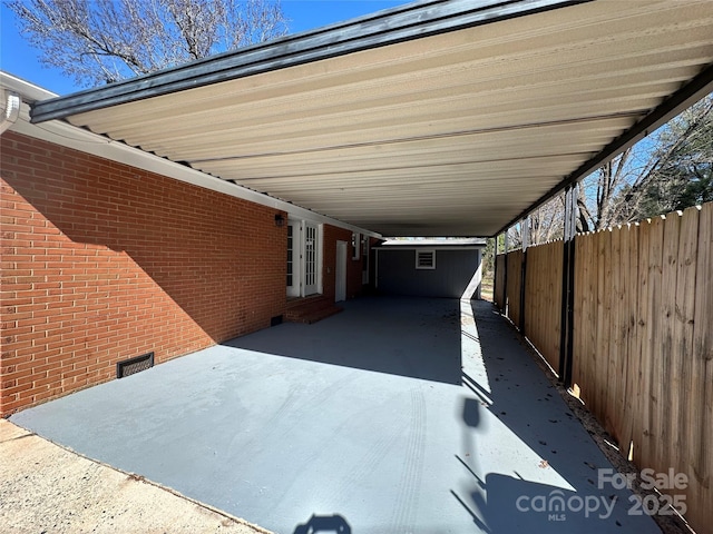 view of vehicle parking with a carport and fence