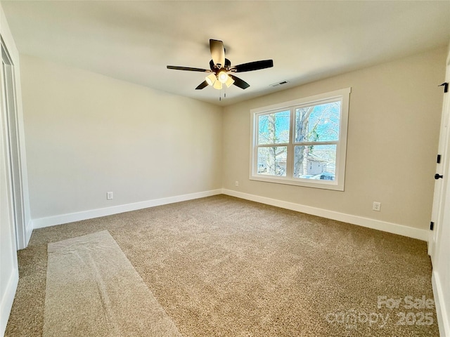 carpeted empty room with visible vents, ceiling fan, and baseboards