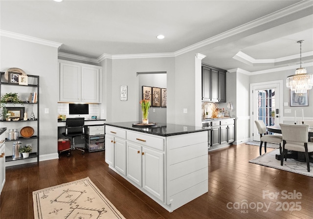 kitchen with white cabinetry, an inviting chandelier, dark wood-style floors, and ornamental molding