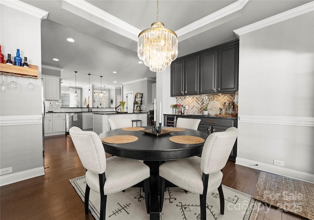 dining space featuring a tray ceiling, an inviting chandelier, ornamental molding, and dark wood finished floors