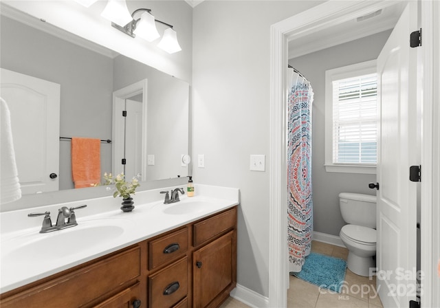 bathroom with tile patterned floors, toilet, double vanity, and a sink