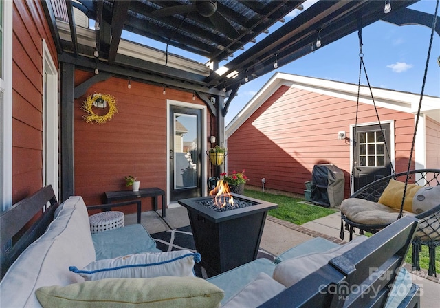 view of patio with an outdoor living space with a fire pit and area for grilling