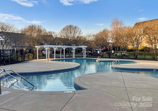 pool with a patio area, fence, and a pergola