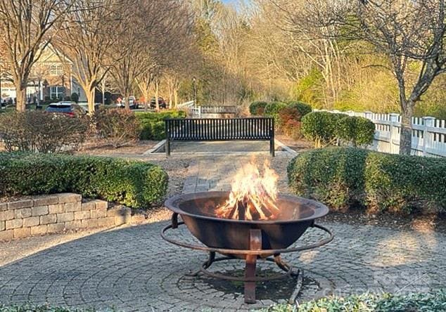 view of home's community featuring a fire pit and fence