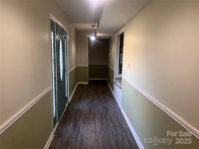 hall with dark wood-style flooring and baseboards