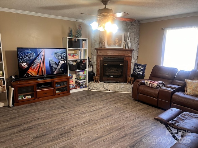 living area featuring a fireplace, crown molding, ceiling fan, a textured ceiling, and wood finished floors