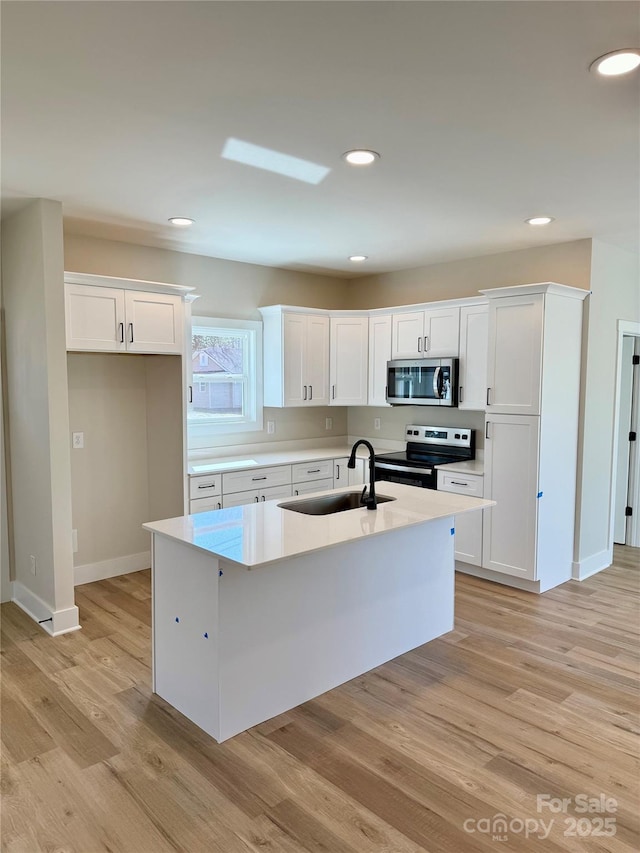 kitchen with white cabinets, stainless steel appliances, and light countertops