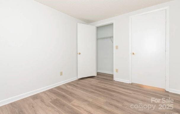 unfurnished bedroom featuring light wood-style flooring and baseboards