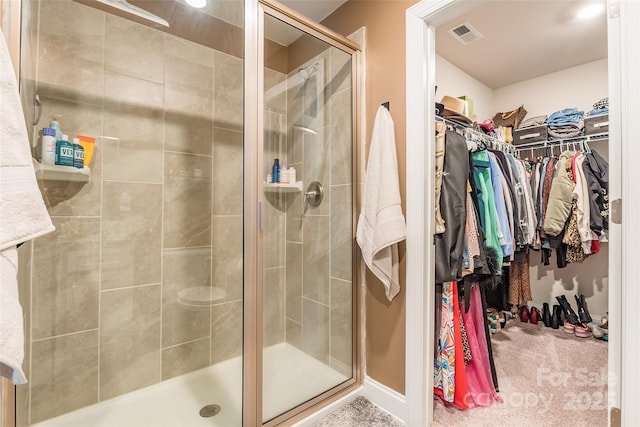 full bathroom featuring a shower stall, a spacious closet, and visible vents