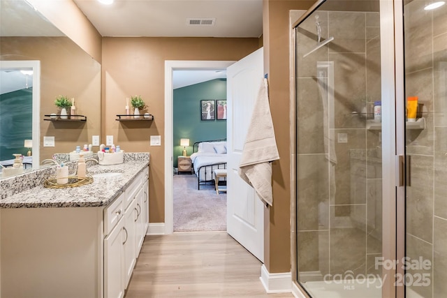 ensuite bathroom with vanity, connected bathroom, visible vents, and a shower stall