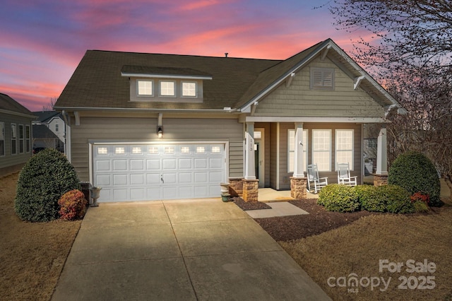 craftsman-style home with concrete driveway, a porch, an attached garage, and stone siding