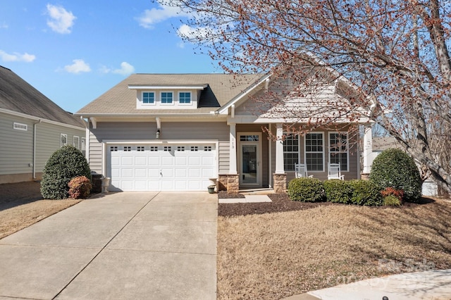 view of front of home with a garage, driveway, and stone siding