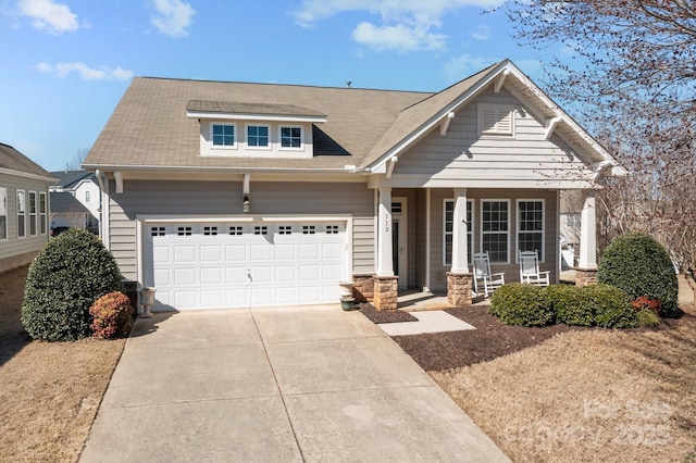 view of front of home featuring driveway, a garage, and a porch