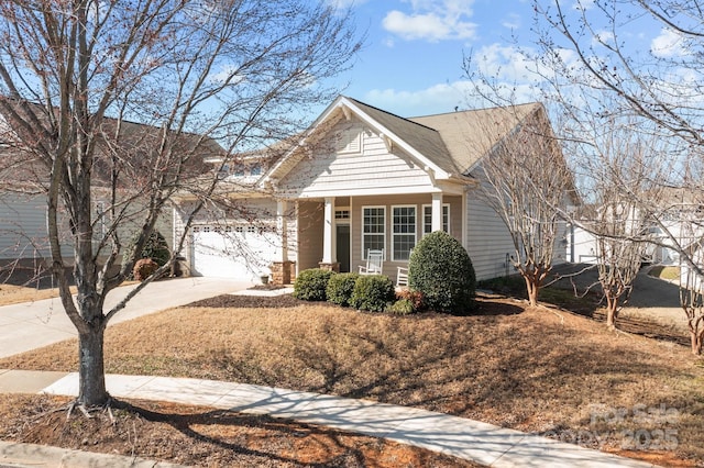 view of front facade featuring an attached garage, covered porch, and concrete driveway