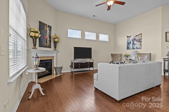 living area with dark wood-style floors, visible vents, plenty of natural light, and a premium fireplace