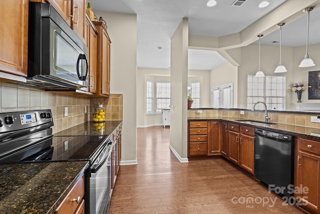 kitchen with black appliances, dark wood-style flooring, a sink, and brown cabinets