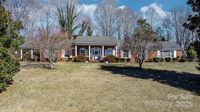 view of front of property with a front yard, covered porch, and brick siding