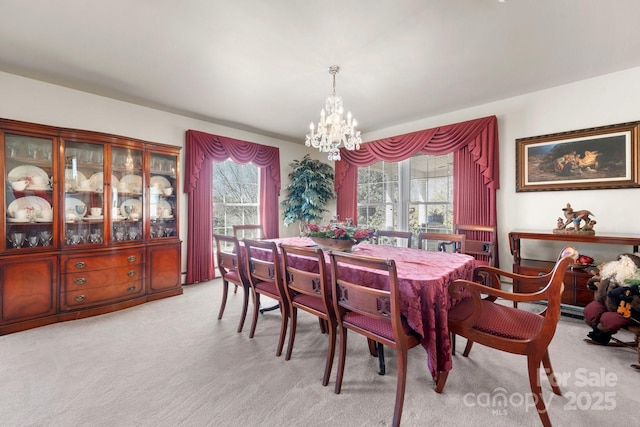 dining room with a chandelier and light colored carpet