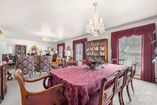 dining space featuring light carpet and a notable chandelier