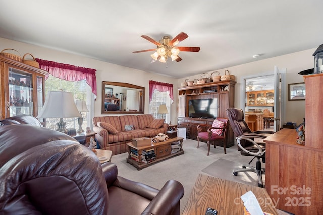 living area with carpet flooring and ceiling fan