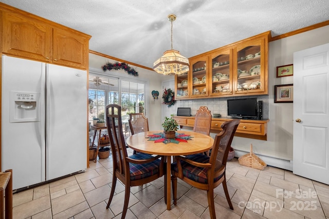 dining space with a baseboard radiator, crown molding, and a textured ceiling