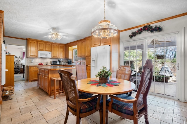 dining room featuring ceiling fan, ornamental molding, and a textured ceiling