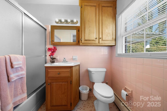 bathroom featuring combined bath / shower with glass door, tile walls, toilet, and vanity