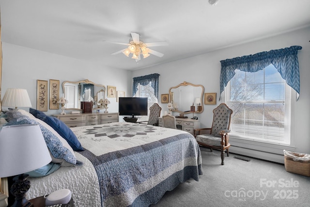 carpeted bedroom featuring ceiling fan, multiple windows, and visible vents