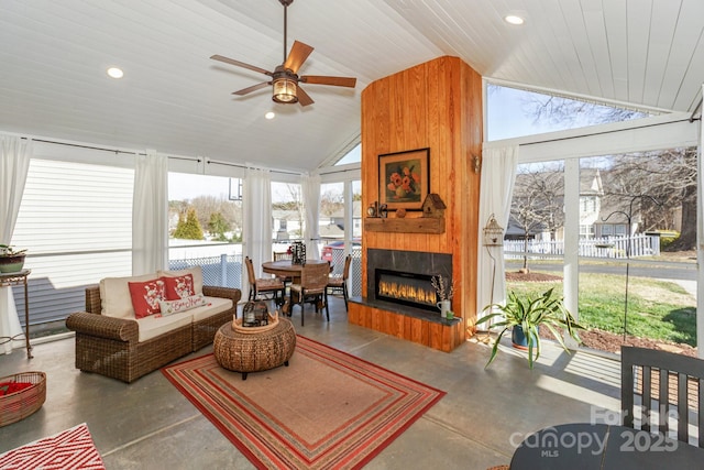 sunroom with lofted ceiling, a large fireplace, wooden ceiling, and a wealth of natural light