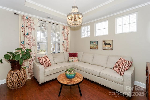 living room featuring ornamental molding, a raised ceiling, visible vents, and wood finished floors