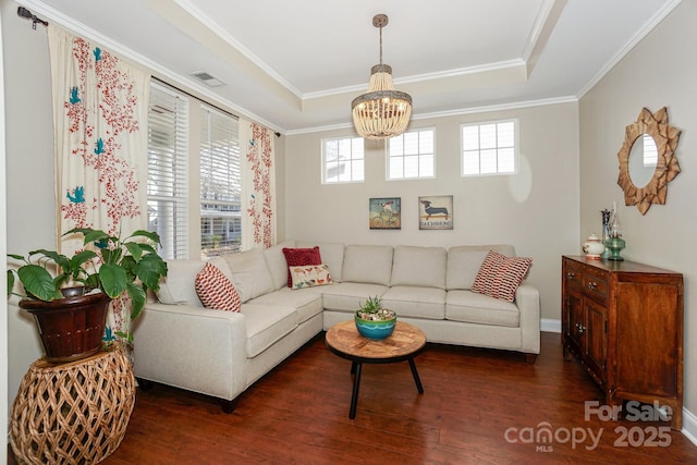 living area featuring plenty of natural light, visible vents, a raised ceiling, and wood finished floors