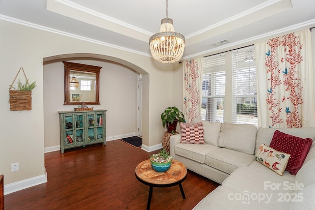 living area featuring crown molding, visible vents, a raised ceiling, and wood finished floors