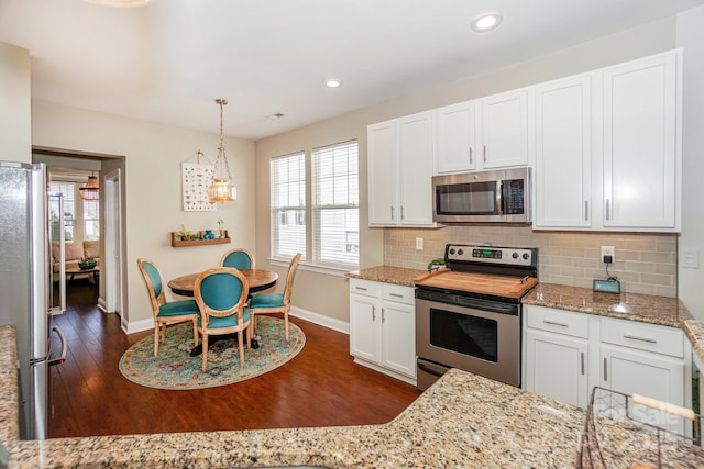 kitchen featuring white cabinets, dark wood-style flooring, stainless steel appliances, and backsplash