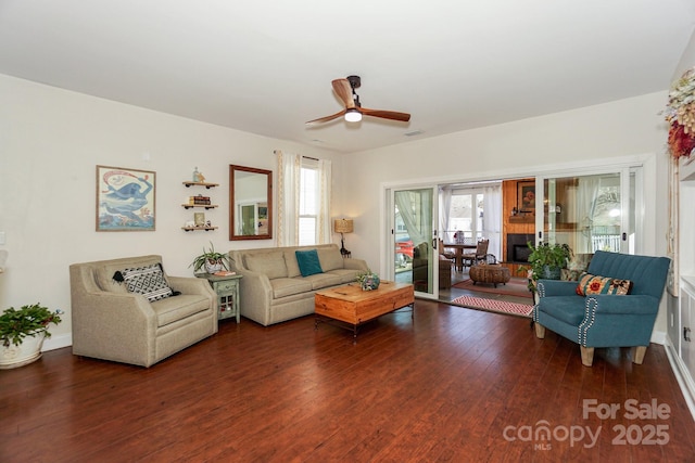 living area with ceiling fan, baseboards, and hardwood / wood-style flooring