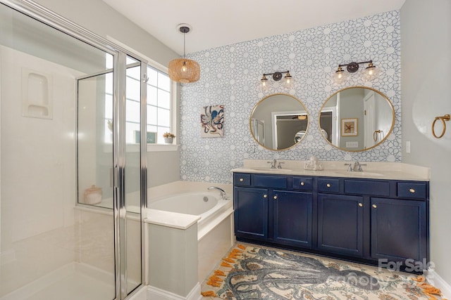 bathroom with a garden tub, a sink, a shower stall, and double vanity